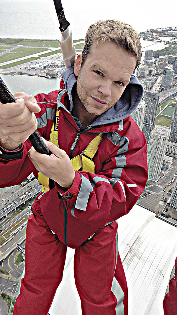 dave stands suspended from the edge of the CN tower in Toronto